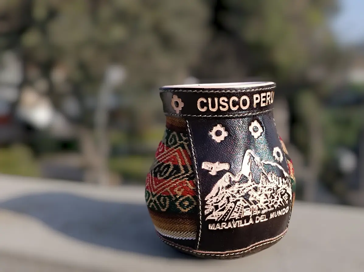 clay cup lined with Andean textiles from Cusco and leather engraved with an image of Machu Picchu (“Wonder of the World”)